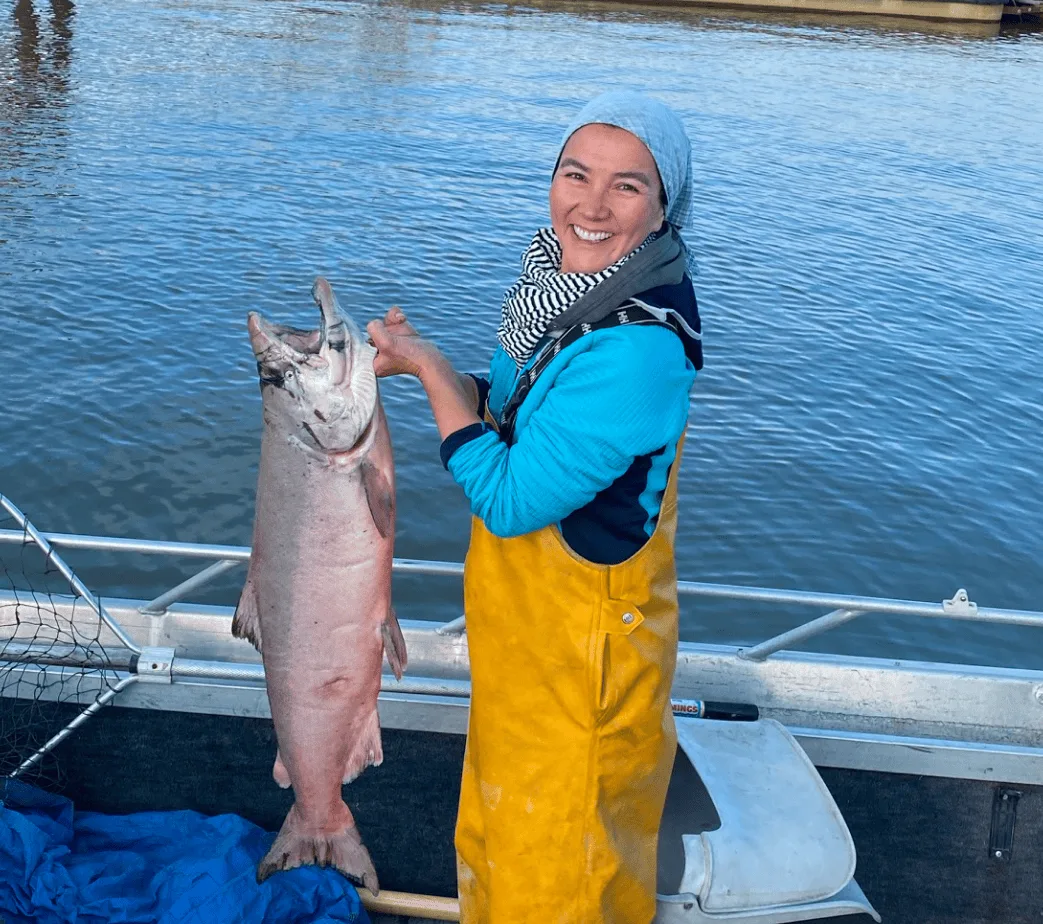 Mary Peltola holding up a king salmon in a skiff.