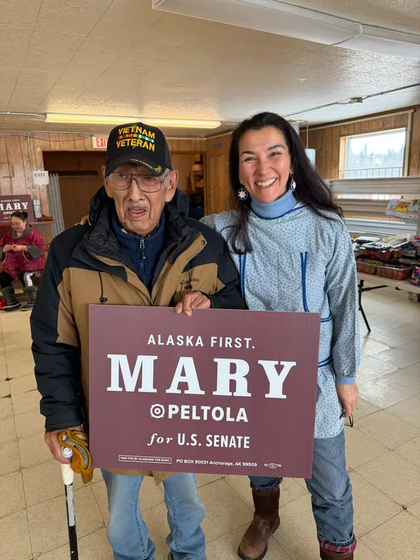 Mary Peltola beside a Vietnam veteran holding a Mary sign.