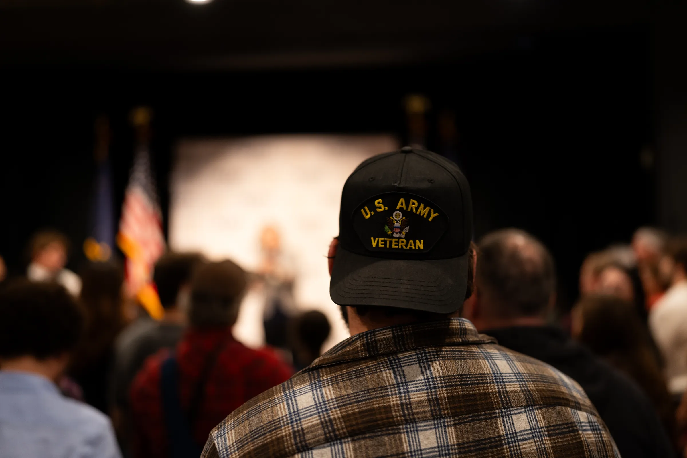 A U.S. Army veteran in his cap, in the crowd at a campaign event.