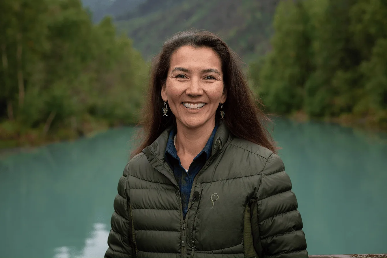 Mary Peltola smiling beside a glacial lake.