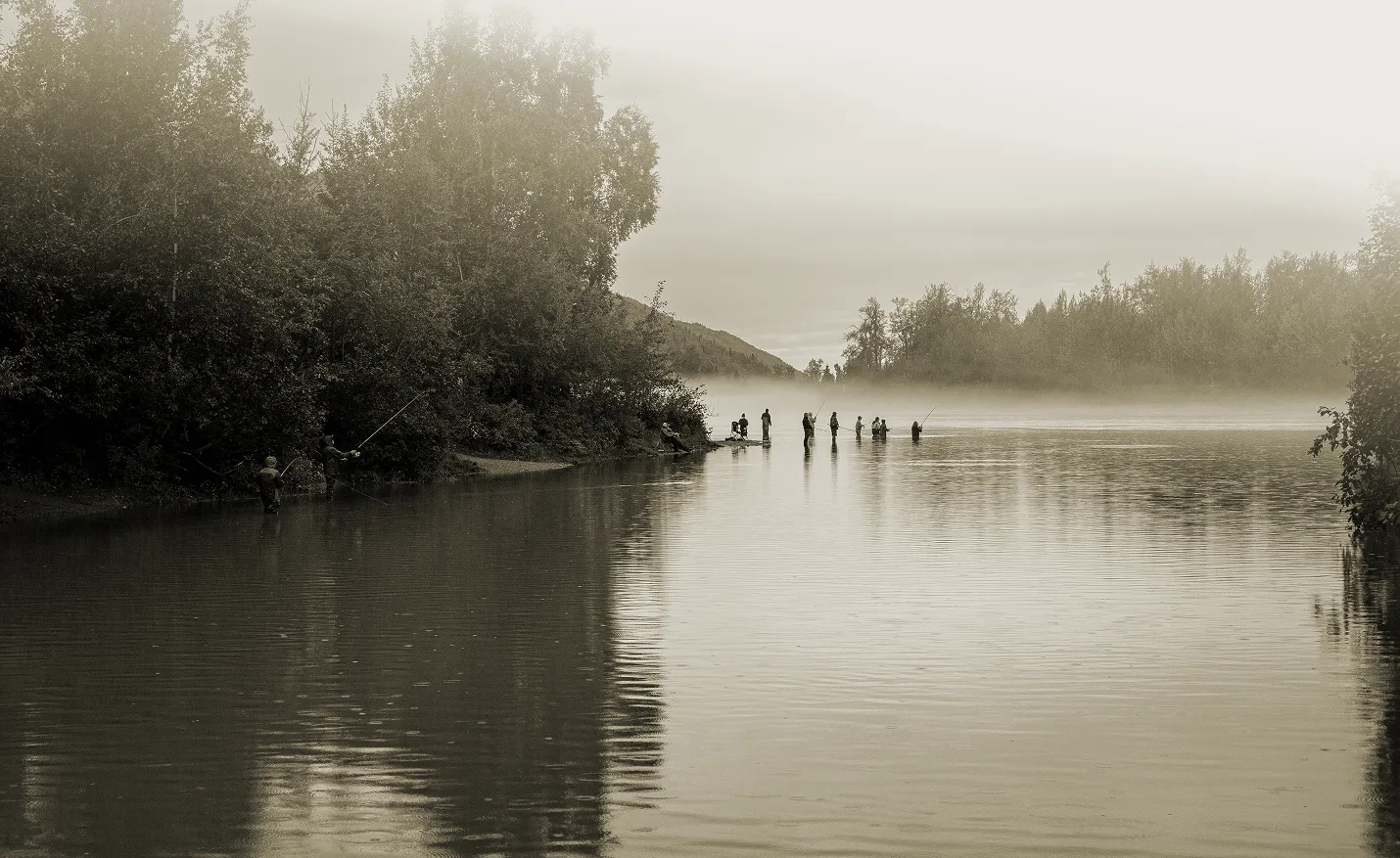 Anglers wade a fog-covered Alaska river at first light.