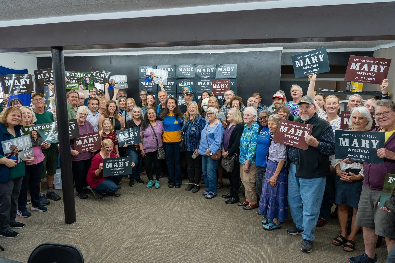 Mary Peltola with a crowd of volunteers holding Mary signs at a canvass launch.