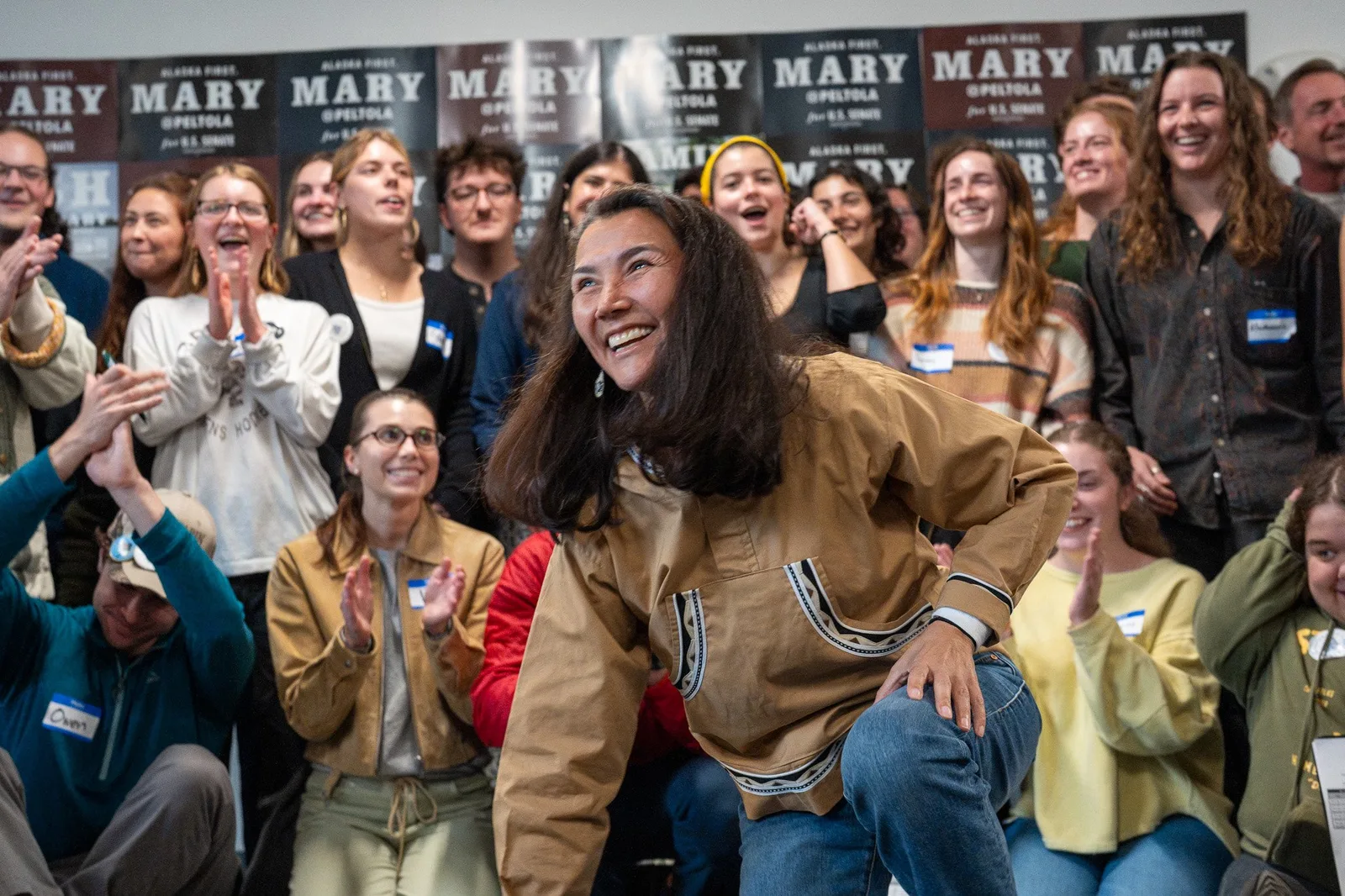 Mary Peltola laughing with cheering volunteers at the Anchorage field office.