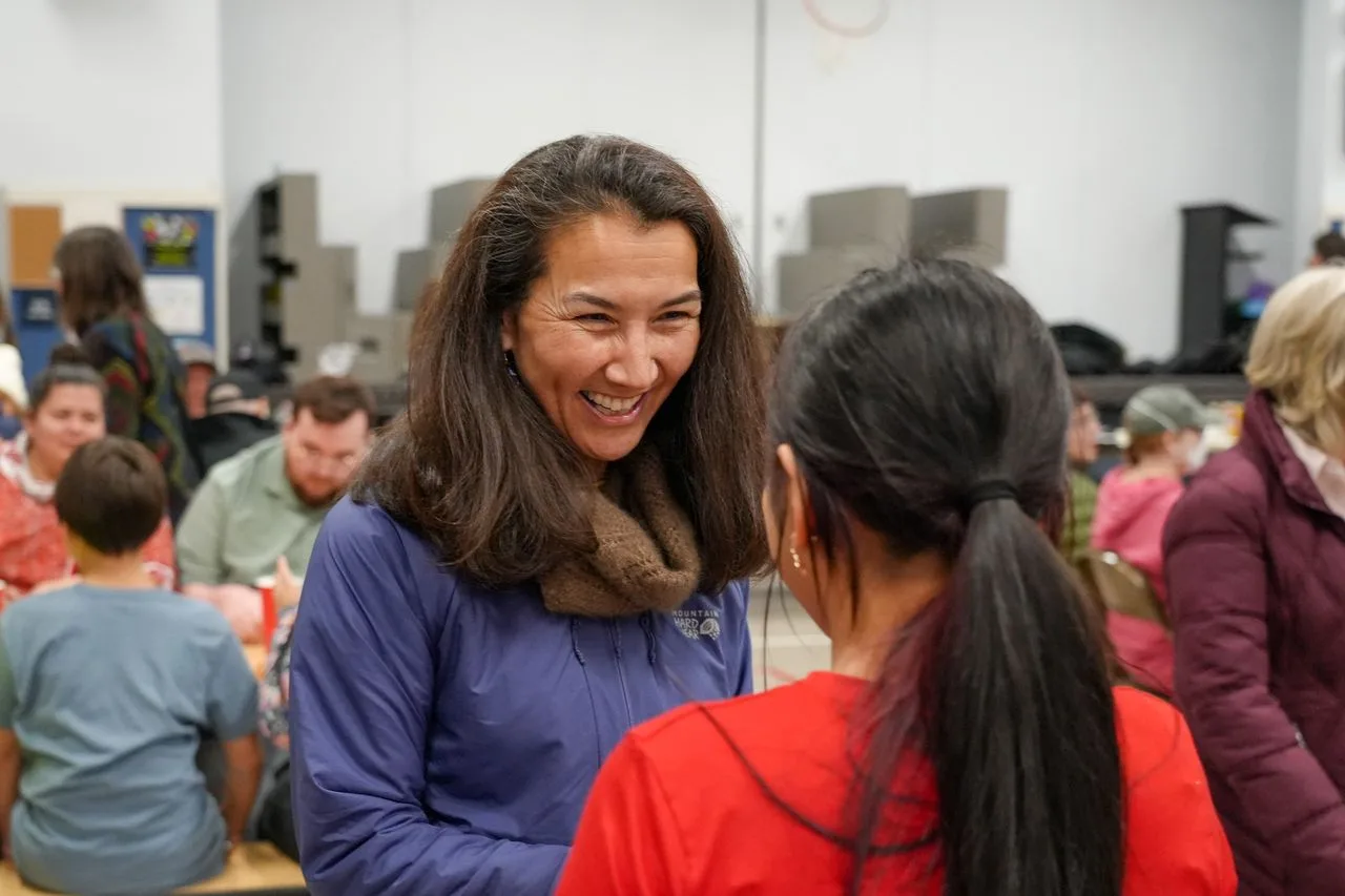 Mary Peltola laughing with a young girl at the meet and greet in Dillingham.
