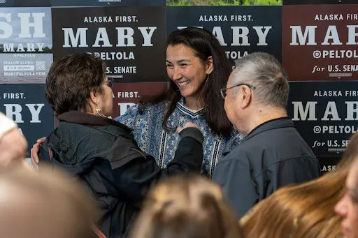 Mary Peltola hugging a supporter in front of Mary signs at the Anchorage field office opening.